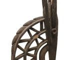 une sculpture en bois représentant une chaise sur laquelle est perché un oiseau