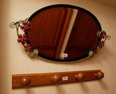 un miroir et un porte-manteau dans un coin de la pièce