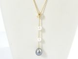 a white mannequin necklace with pearls and a gold chain