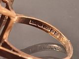 a close up of a gold ring with a diamond on it