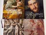 trois livres posés sur une table, à côté d'un tableau représentant un homme et une femme