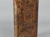 an old book sitting on top of a white surface