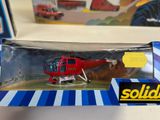 a red helicopter in a box on a table