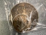 a silver coin in a plastic bag on a table