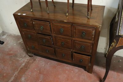 a wooden dresser with many drawers and a mirror on it