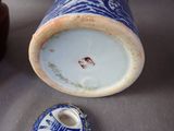 a blue and white vase with a lid on a table