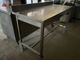 stainless steel work table in a commercial kitchen with a person in the background