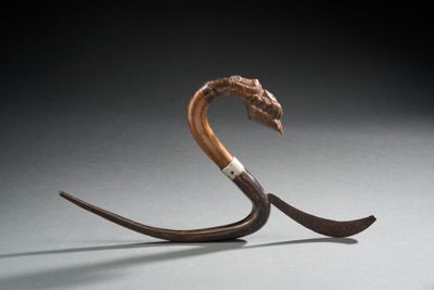 une sculpture représentant un serpent avec une longue queue sur le dos