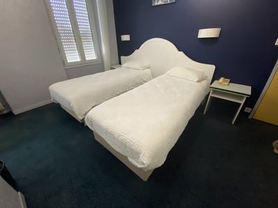 two beds in a room with blue walls and a white headboard