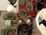 a lot of pots and cups on the table