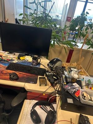un bureau sur lequel se trouvent un ordinateur, un clavier et un casque