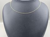 a black mannequin with a gold chain on top of it