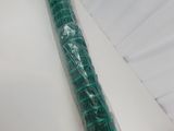un rouleau de plastique vert emballé dans du plastique, posé sur une surface blanche