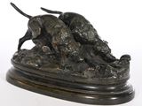 statue en bronze représentant deux chiens sur un rocher, sur fond blanc