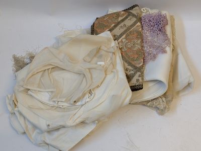 a pile of cloth on the floor next to a pair of scissors