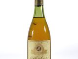 une vieille bouteille de vin posée sur une surface blanche