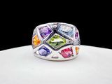 un gros plan d'une bague ornée de pierres multicolores sur un fond blanc