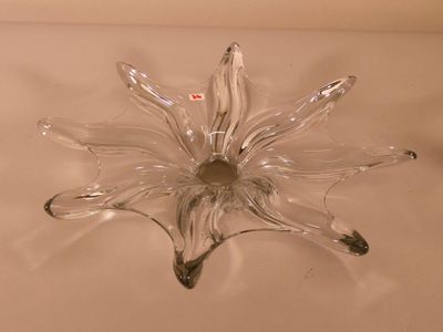 a clear glass flower shaped object on a white surface