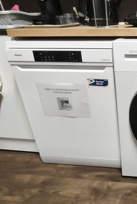 une photo d'une machine à laver blanche dans une cuisine