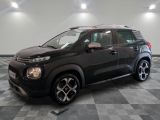 la voiture noire est garée sur un sol en damier dans le garage