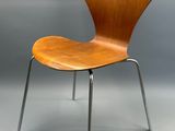 un gros plan d'une chaise en bois avec des pieds en métal