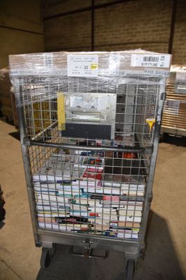 a metal cart with many boxes on it in a warehouse