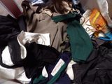 a pile of clothes that is sitting on a bed