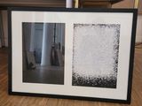 two framed pictures on a wooden floor in a room