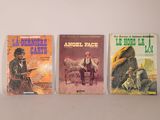 three books are lined up on a shelf on a white surface