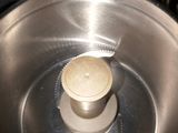 a metal bowl with a wooden lid on top of a stove