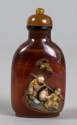 a brown glass bottle with a gold decoration on it