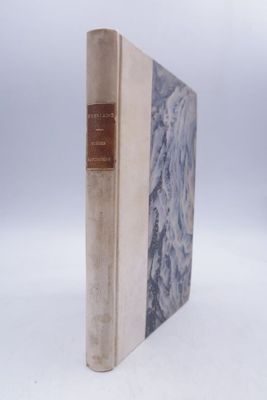 an old book sitting on top of a white table next to a white wall