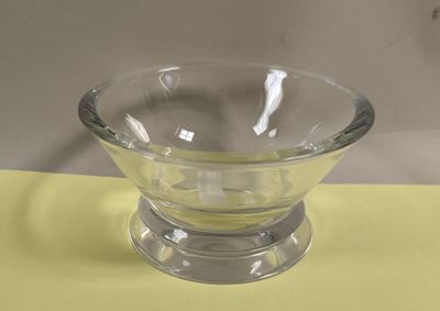 a glass bowl on a yellow tablecloth on a table
