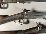 several old guns are lined up on a white surface