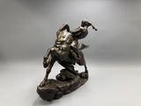 a bronze statue of a man riding a horse on a rock