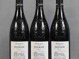 three bottles of red wine sitting on top of a table