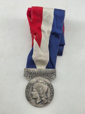 an image of a silver medal with a red, white and blue ribbon
