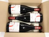 three bottles of wine in a cardboard box on a table