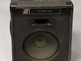 an old amp with a speaker on top of it on a white surface