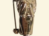 une figurine en or représentant un homme avec un chapeau et une canne