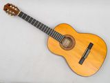 a small wooden guitar sitting on top of a white surface