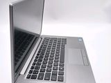 a silver laptop with a black keyboard on a white surface