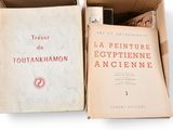 books in a cardboard box on a white surface with a white background