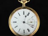 une montre de poche en or avec des chiffres romains sur le cadran