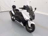 une photo d'une moto blanche et noire garée dans une pièce