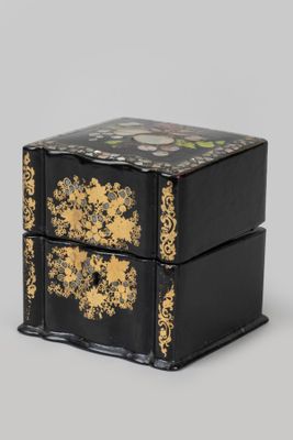 une image représentant une boîte noire et dorée posée sur une table