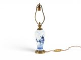 une image représentant une lampe sur laquelle est posé un vase bleu et blanc