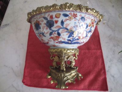 un grand saladier posé sur un support recouvert d'une nappe rouge