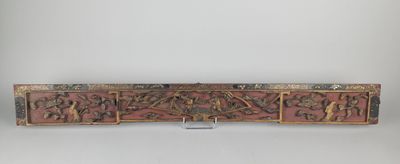 une sculpture en bois représentant un groupe de personnes sur fond rouge