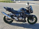 a black motorcycle parked in a parking lot on a sunny day